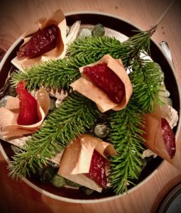 Plate of salmon candy atop fir boughs